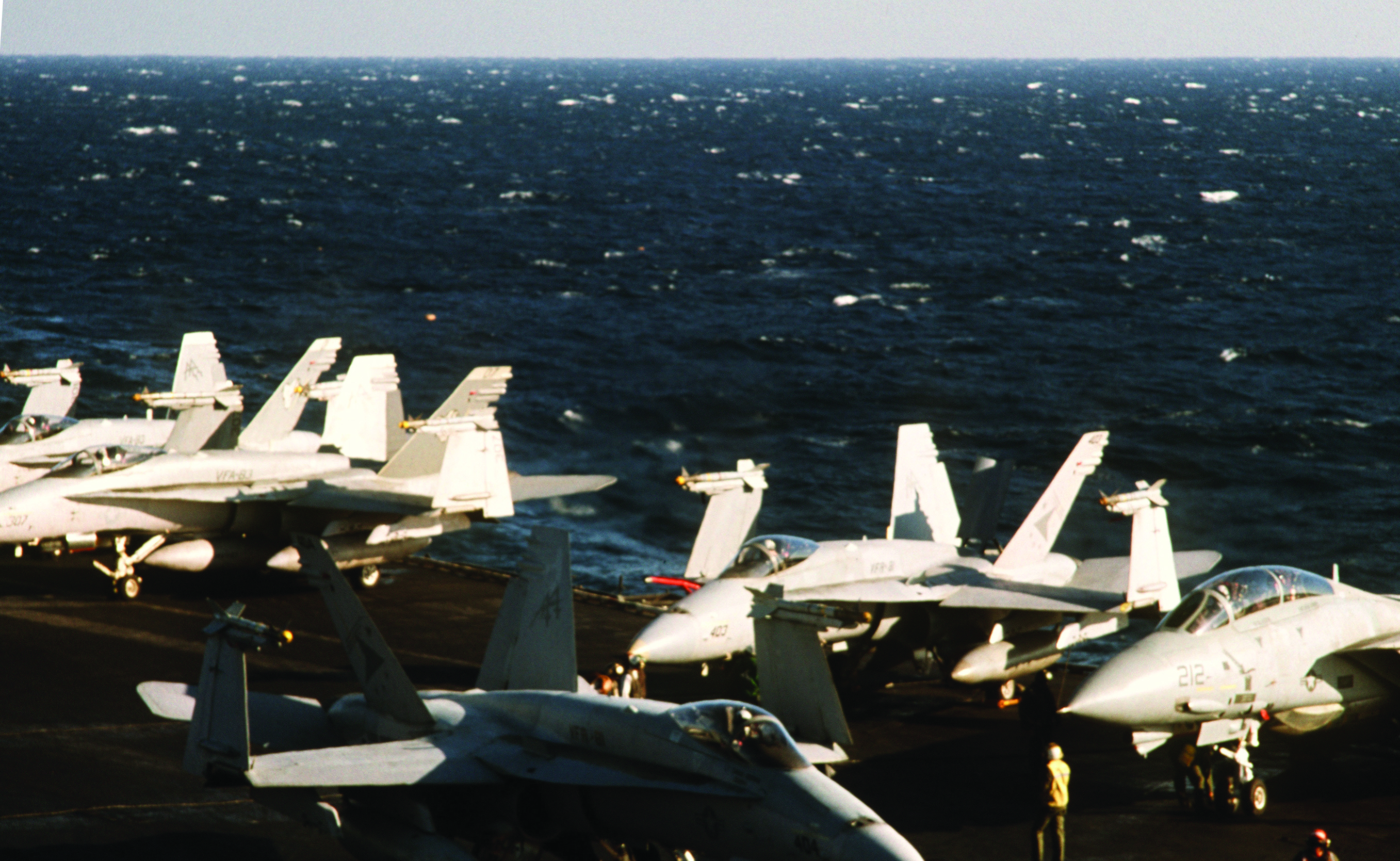 F/A-18 Hornet and F-14 Tomcat fighter jets from Captain Speicher's squadron parked on the flight deck of the USS Saratoga at sea.